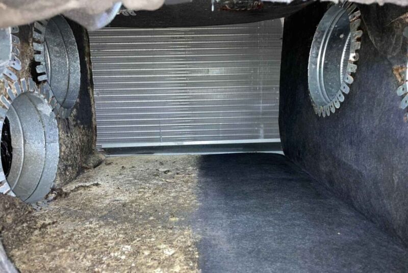 A dirty room with clutter, a door, & window, stressing the critical need for air duct mold removal.